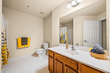 A bathroom with a toilet, sink, and mirror.